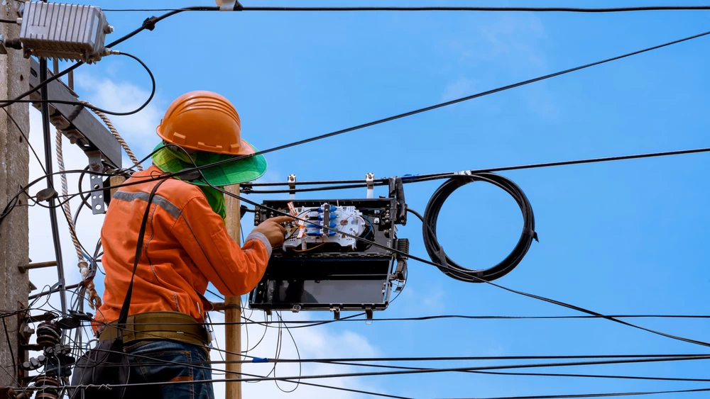 Technician installing equipment on a utility pole